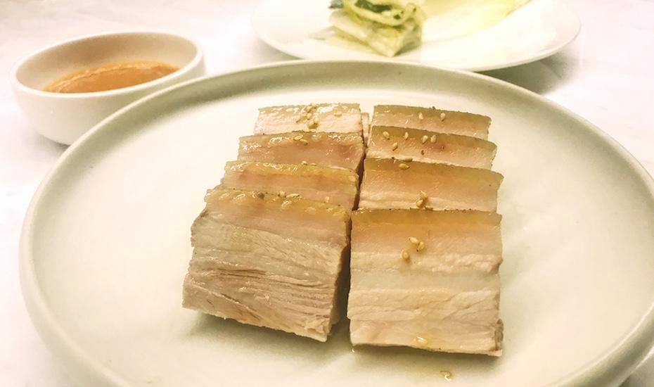 Kimme's take on traditional bossam: that pork belly is cooked for 12 hours. Wrap it in the endive leaves with white kimchi and chilli paste.