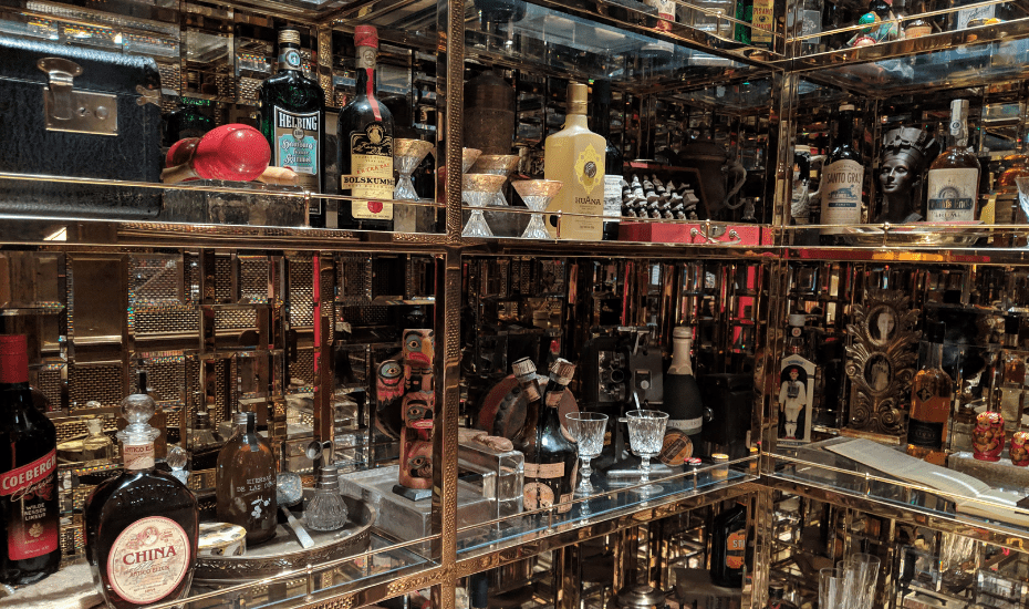 Idlewild's cabinet of curiostiy holds rare spirits, antiques found along the transatlantic route, old paper clippings and luggage tags even.