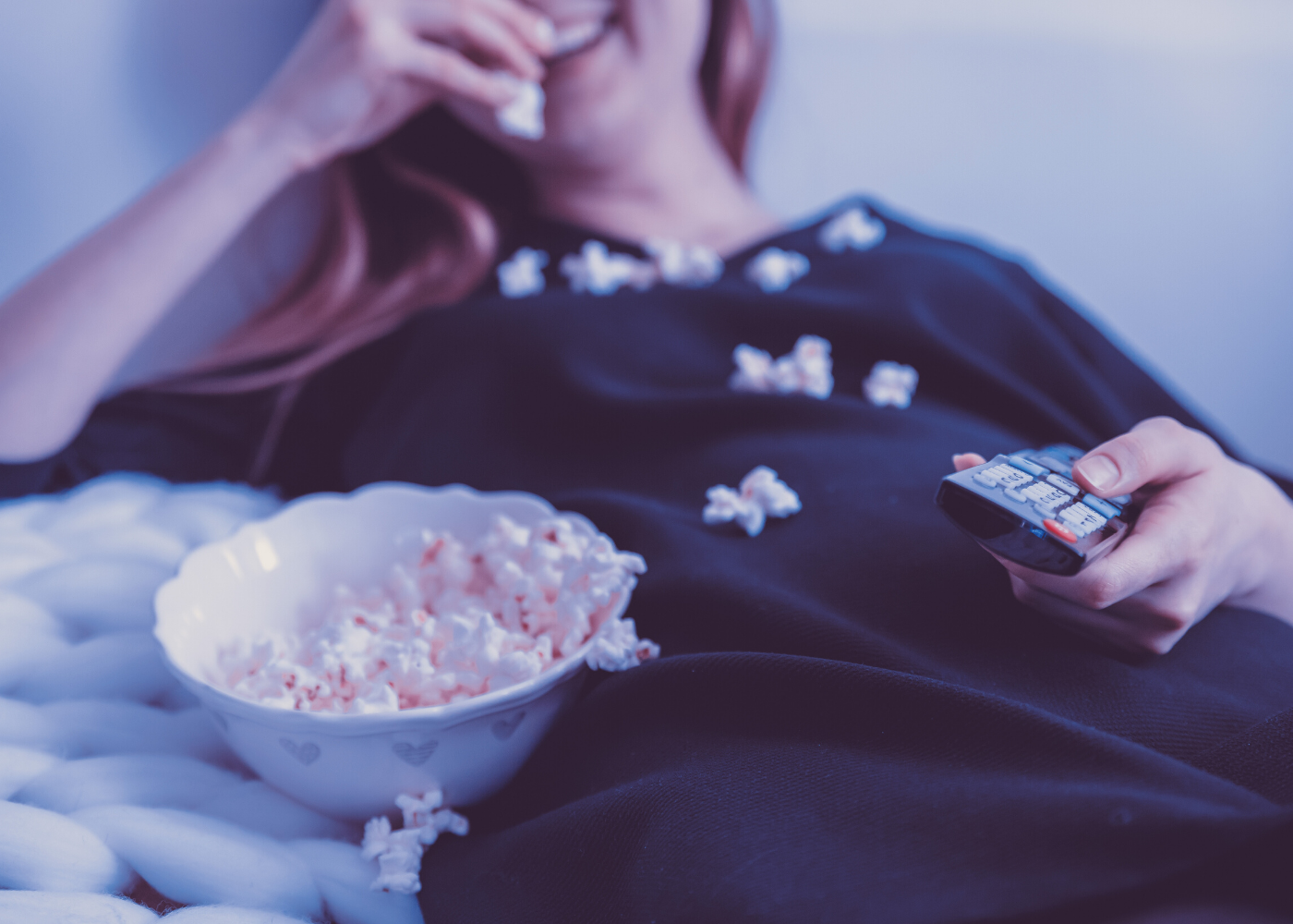 woman watching tv with popcorn
