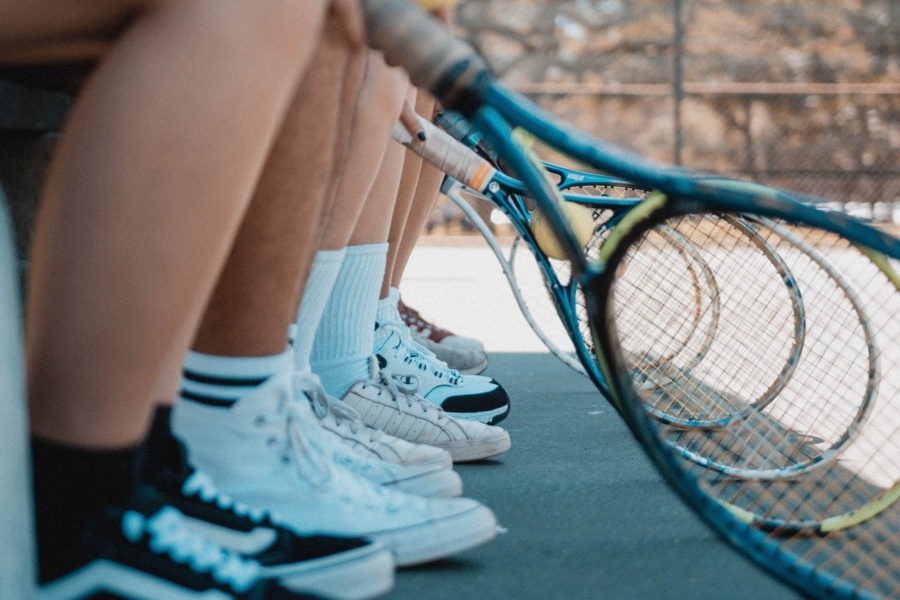 a line of rackets and legs
